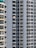A close-up view of several high-rise apartment buildings with numerous balconies, each adorned with railings. Some balconies have laundry hanging, adding a touch of everyday life. Air conditioning units are visible on the outer walls, reflecting an urban residential setting.