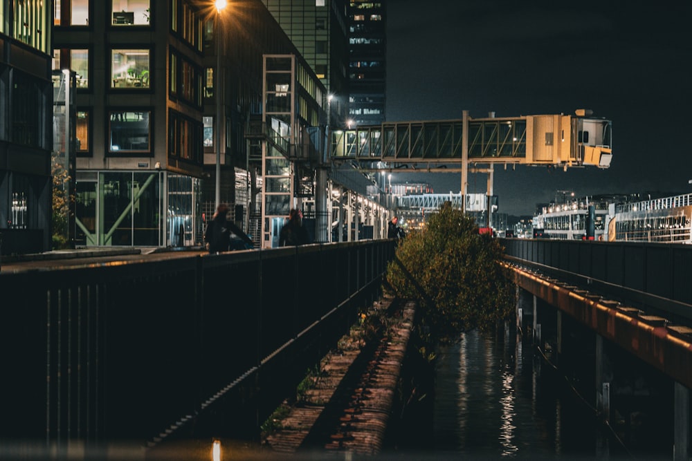 a city street at night with people walking on the sidewalk