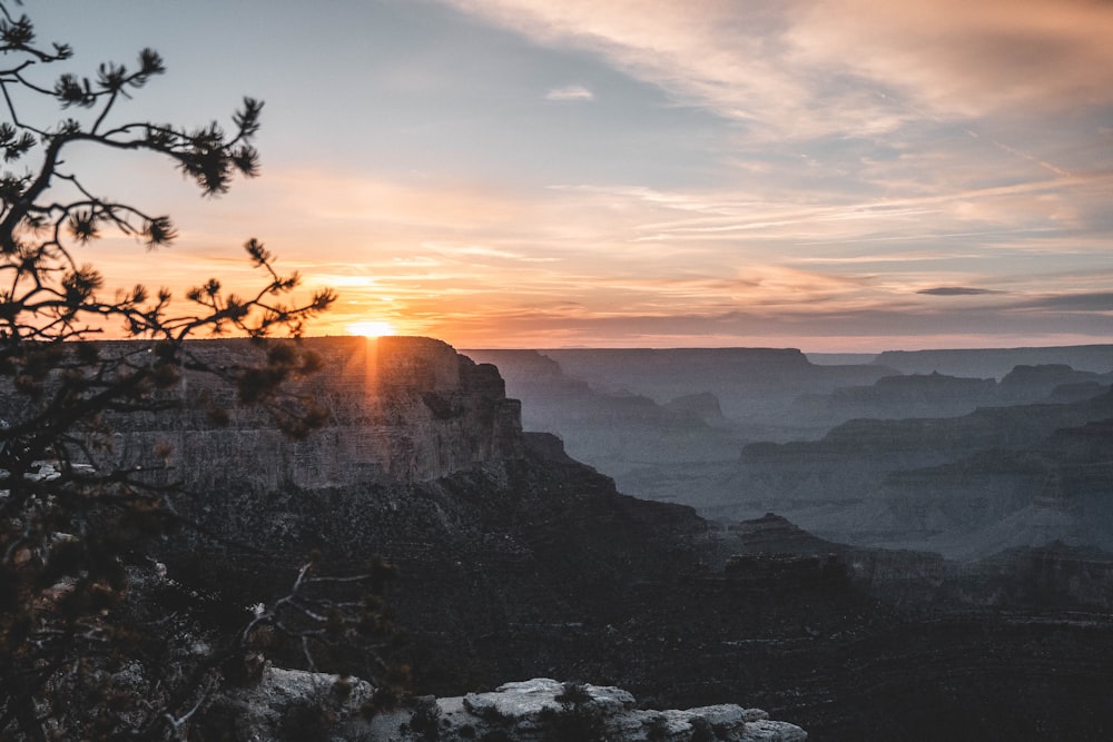 the sun is setting over a canyon in the mountains