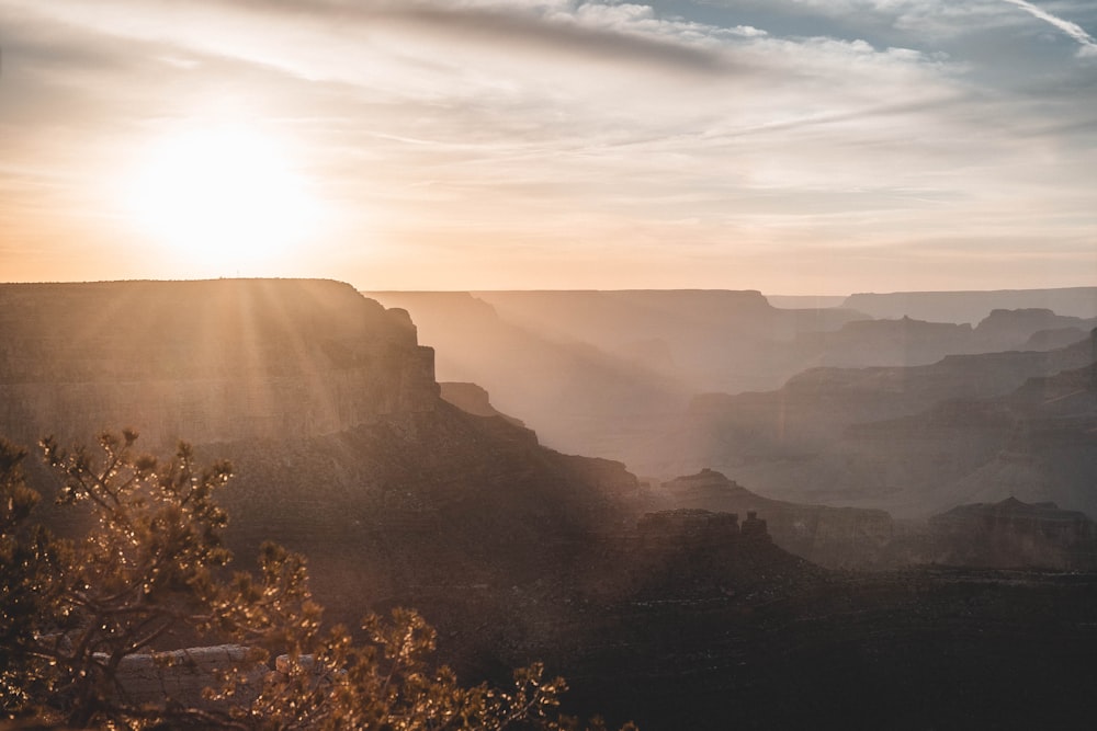 the sun is setting over a canyon in the desert