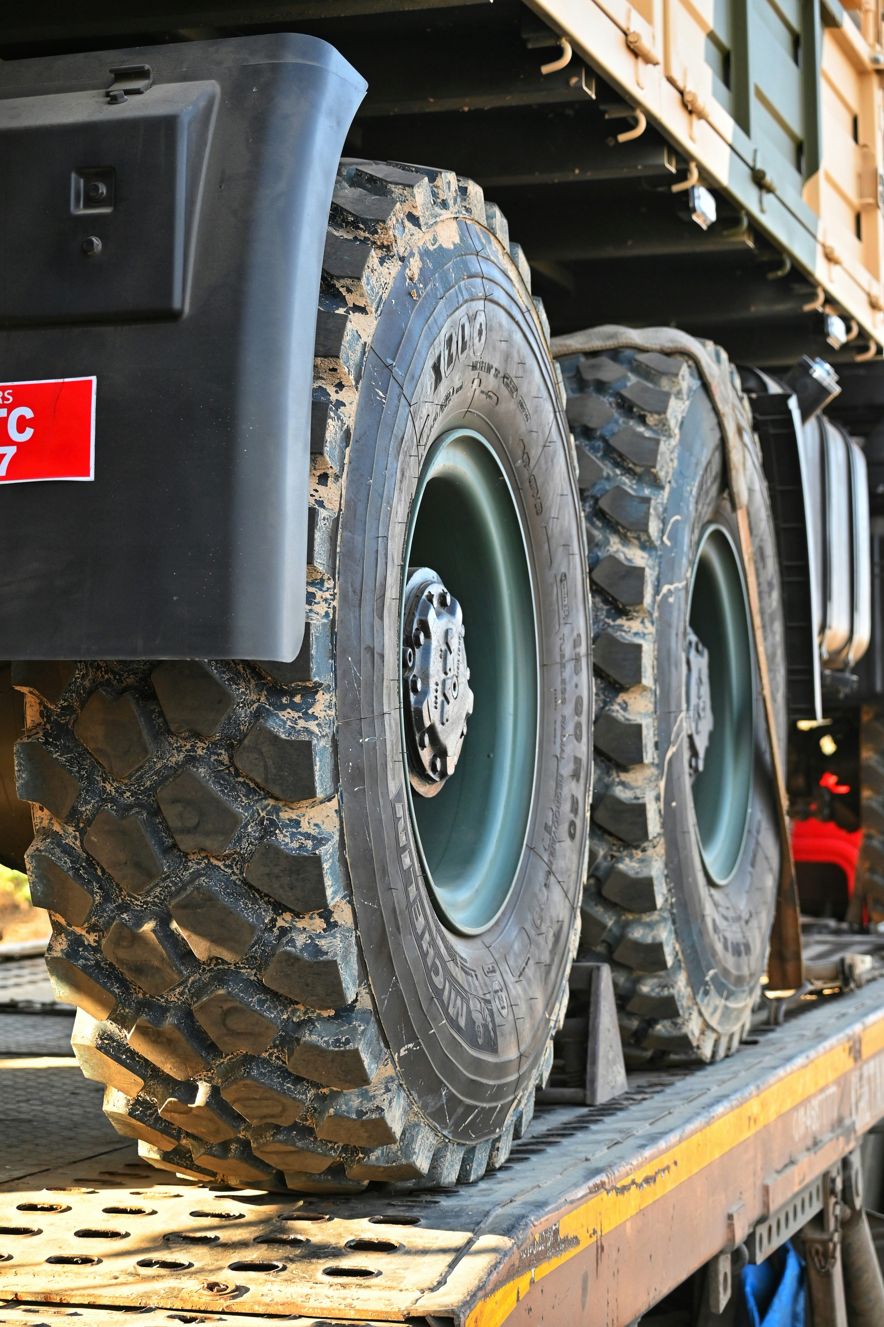 a flatbed truck with two large tires on it's flatbed