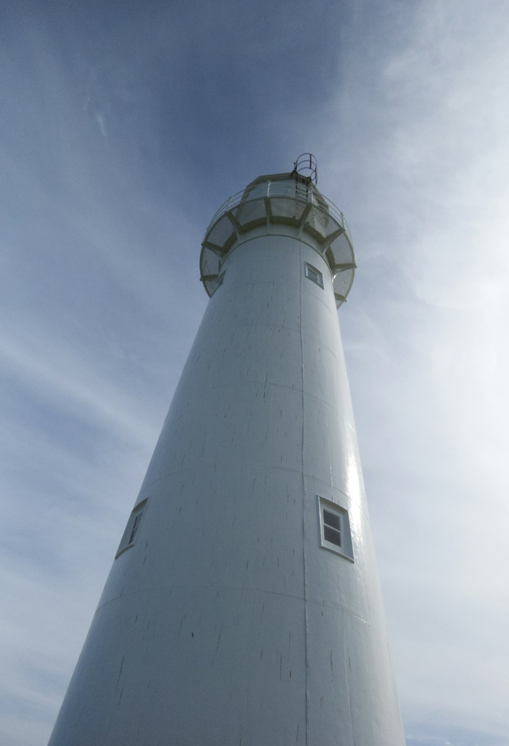 a large white light house sitting on top of a hill