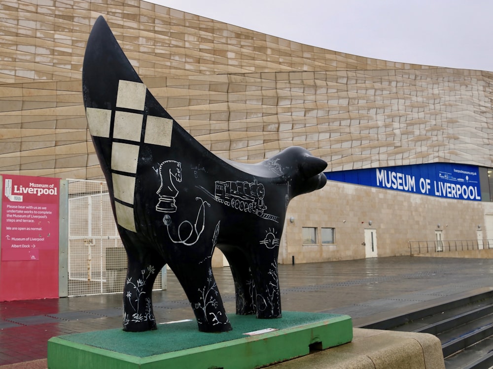 a statue of a dog is in front of a building