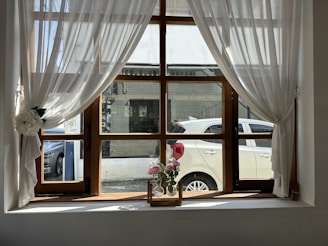 a vase of flowers sitting on a window sill