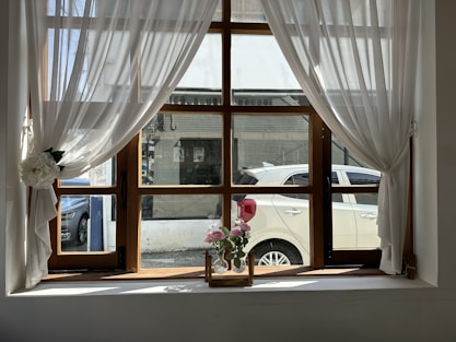 a vase of flowers sitting on a window sill