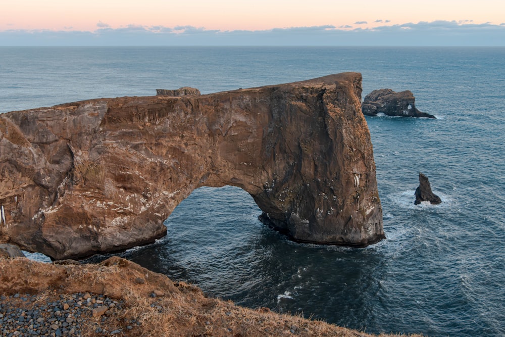 a large rock formation in the middle of a body of water