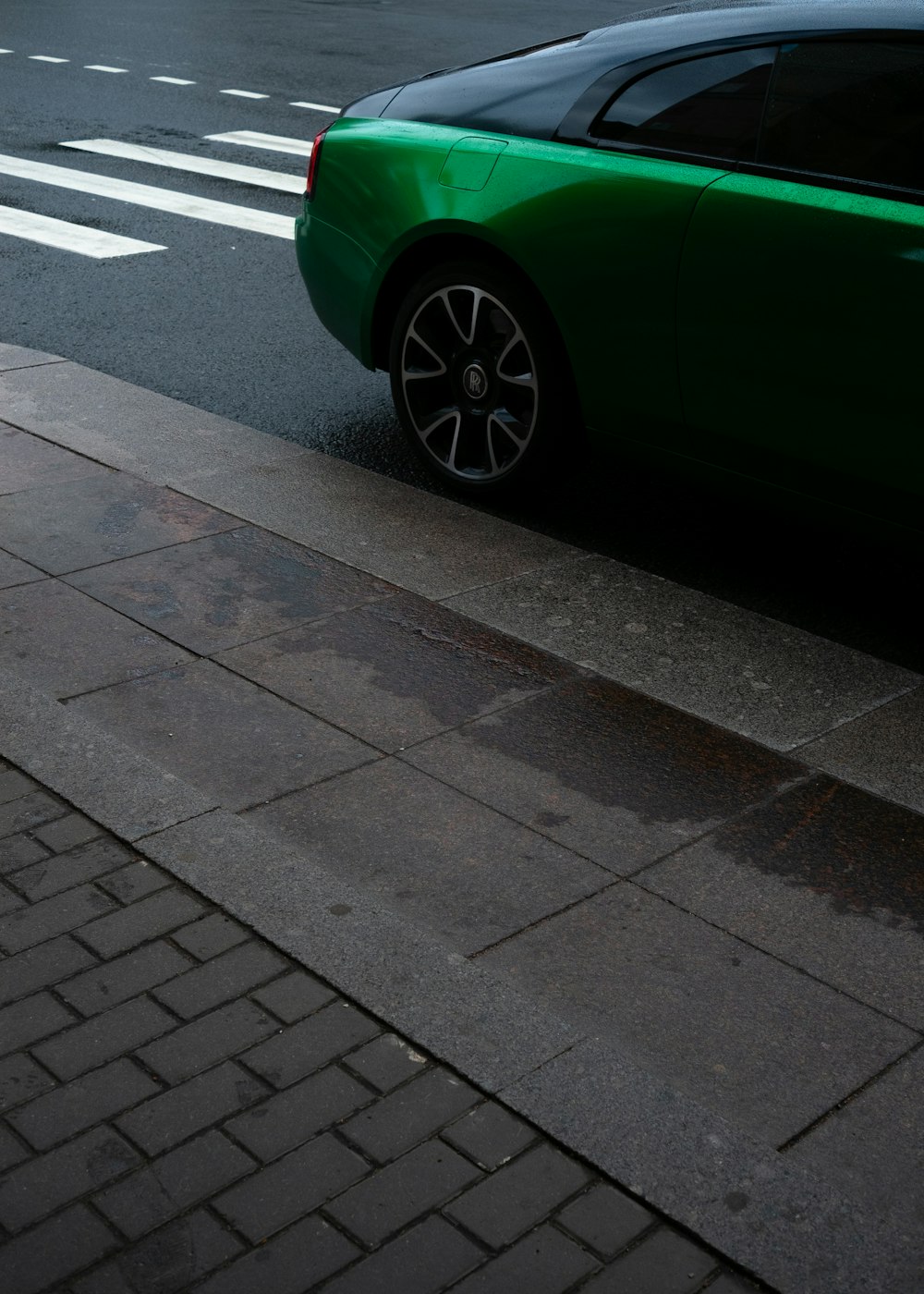 Un coche verde aparcado a un lado de la carretera