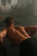 a man with no shirt is doing a back stretch