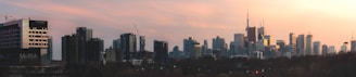 Modern city skyline viewed from a high-rise building during sunset.