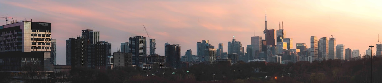 Modern city skyline viewed from a high-rise building during sunset.