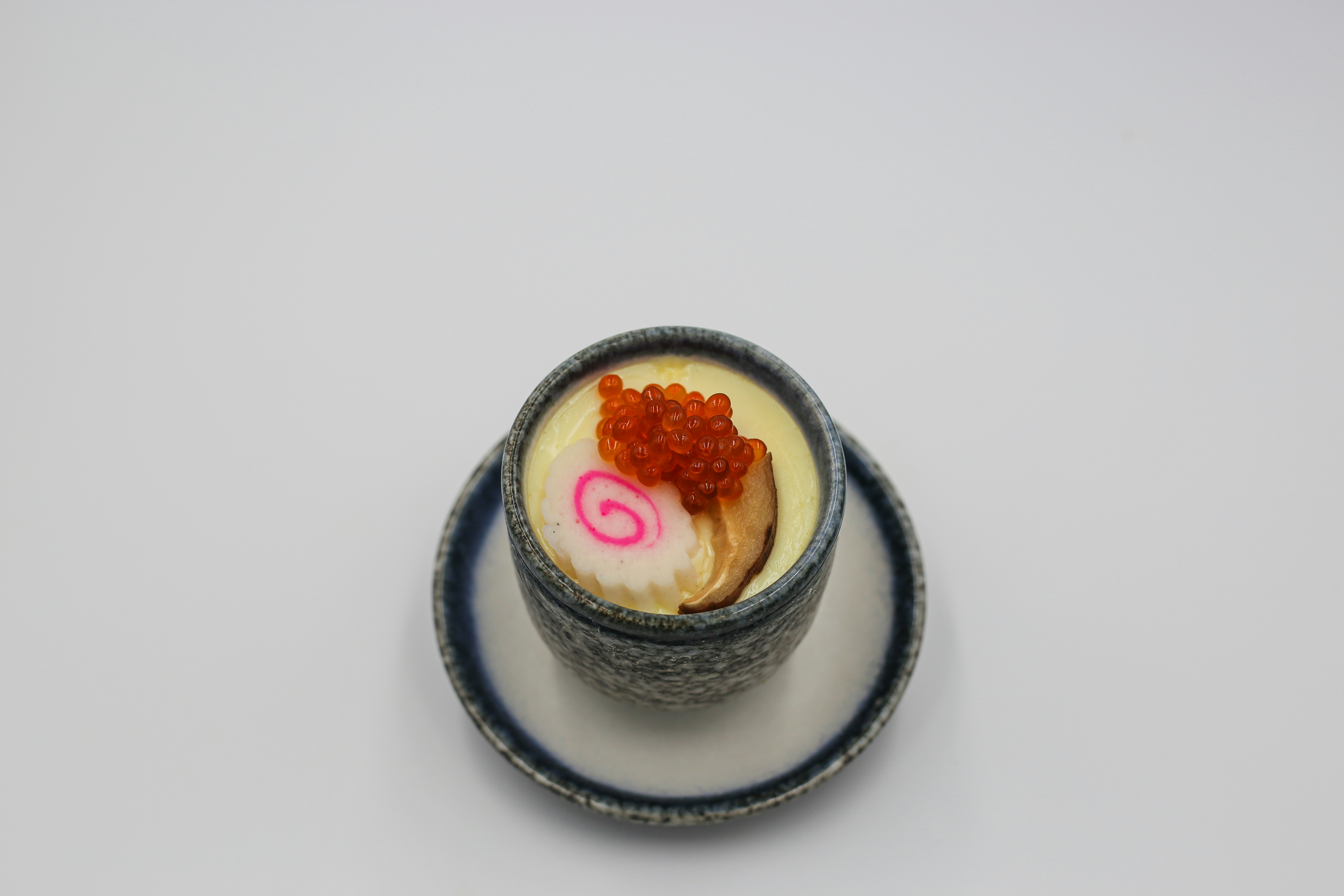 eine kleine Schüssel mit Essen auf einem Teller