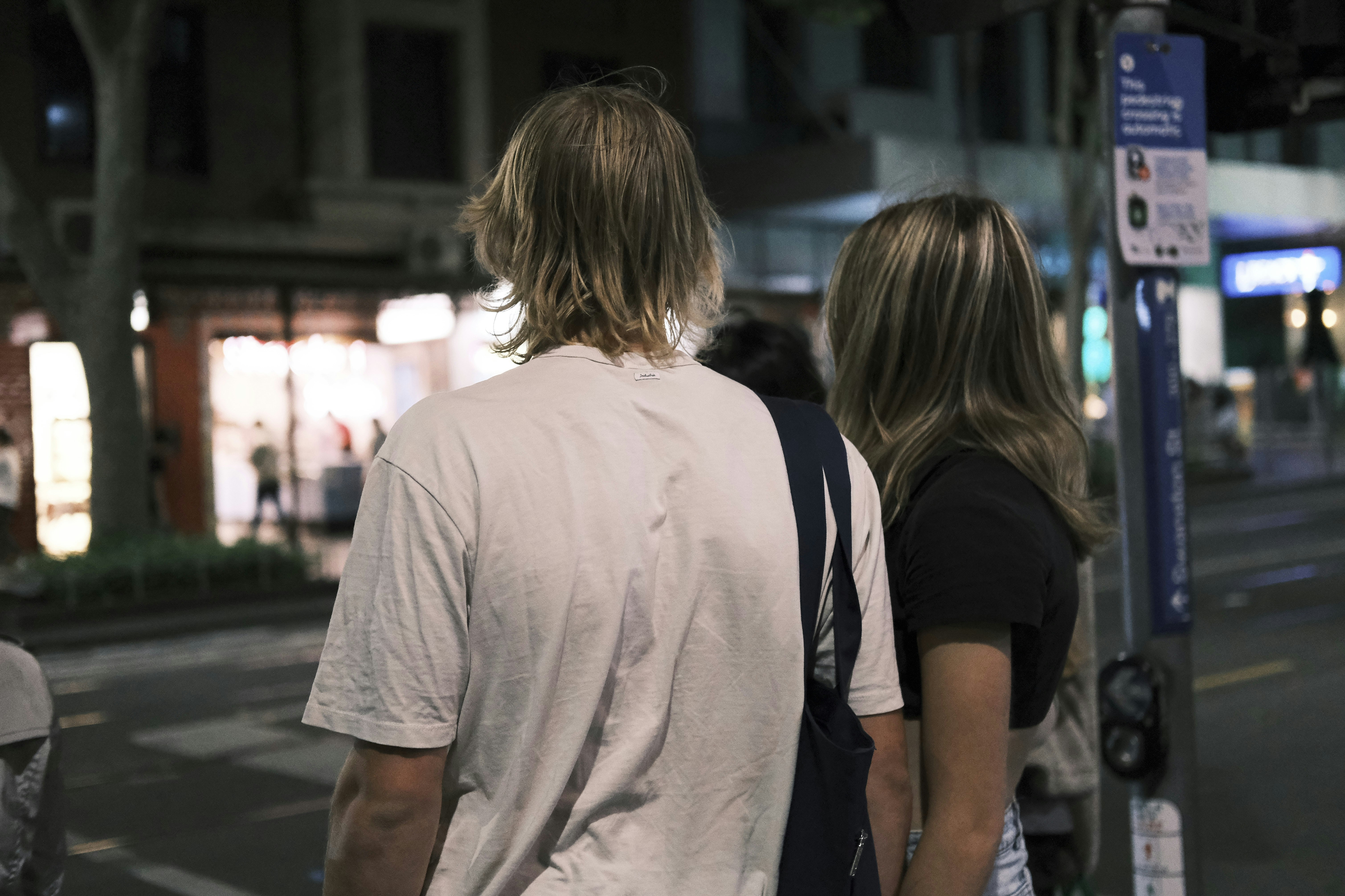 Man and woman walking down a city street at dusk