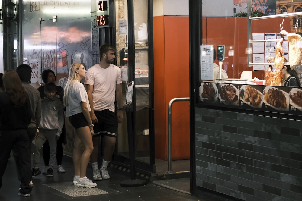 a group of people standing outside of a restaurant