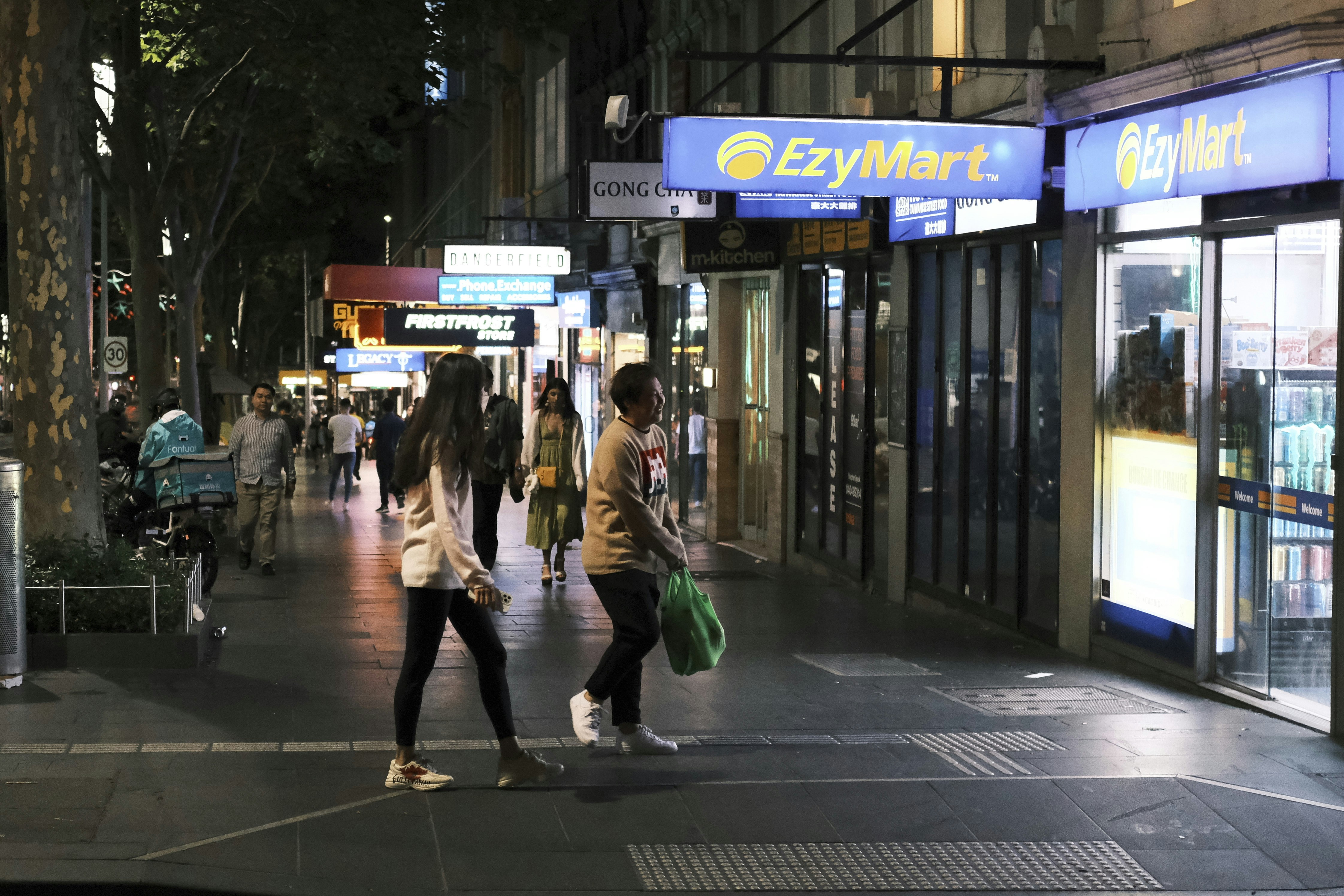 a group of people walking down a street at night
