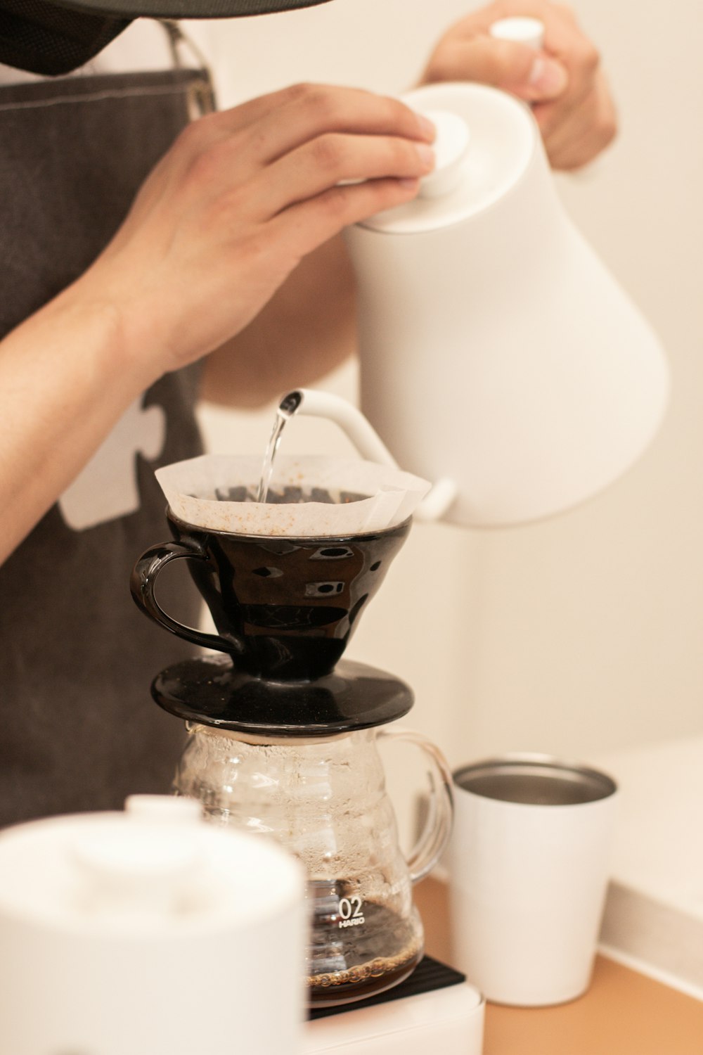 a person pours a cup of coffee from a coffee maker