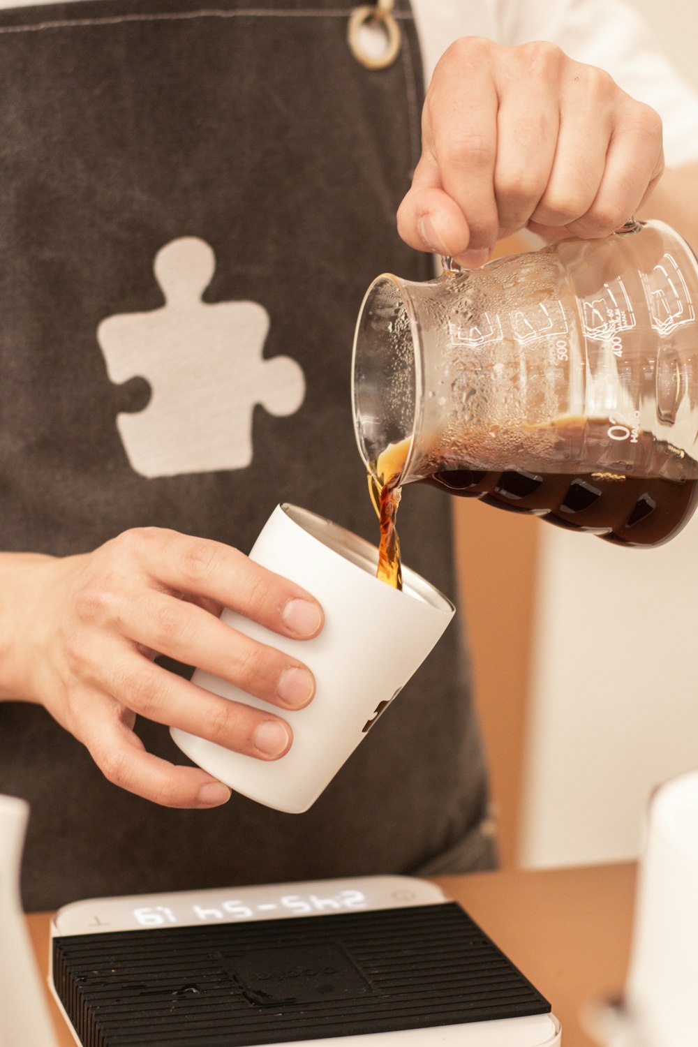 a person pouring coffee into a cup