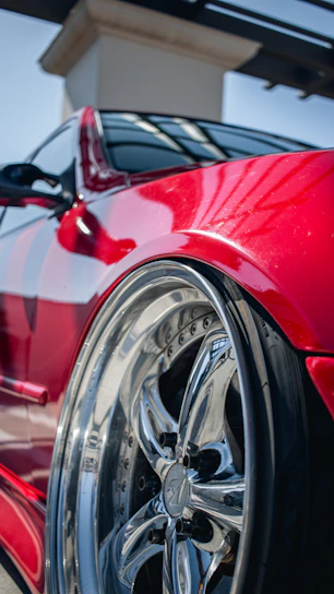 Close-up of a shiny alloy wheel reflecting sunlight on a sleek car.