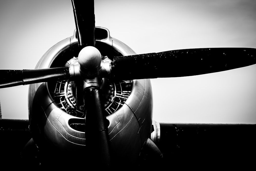 a black and white photo of a propeller plane