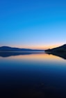 a body of water with mountains in the background