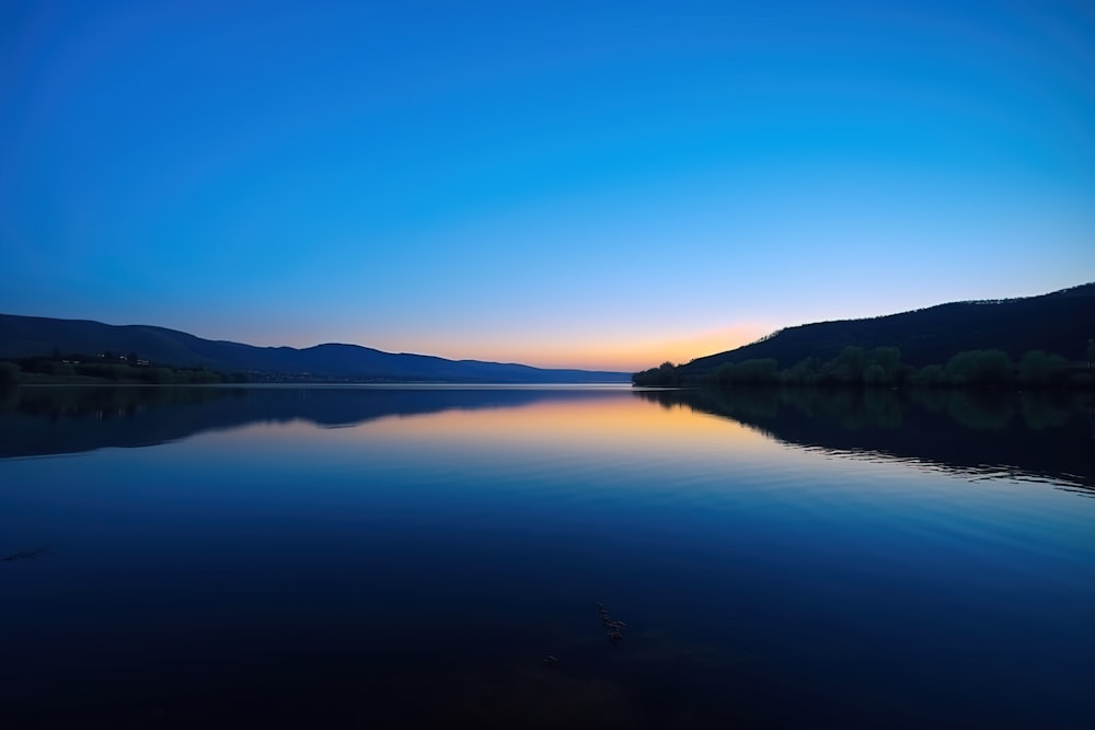 a body of water with mountains in the background