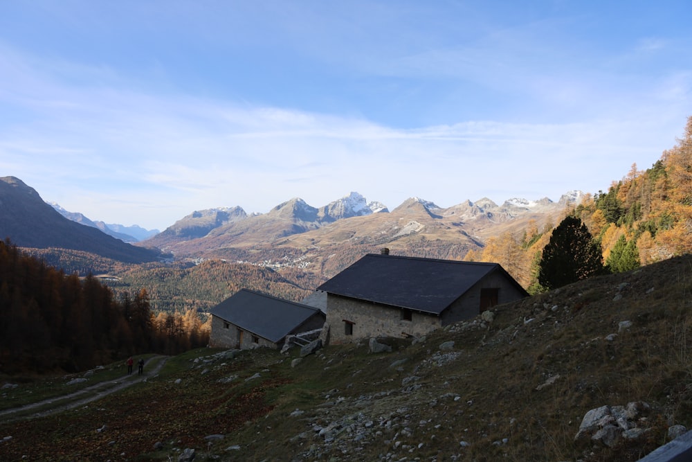 a house on a hill with mountains in the background