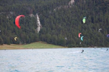 A group of friends riding colorful wakeboards on a sparkling lake