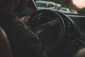 a man driving a car on a busy street