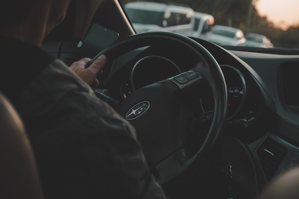 a man driving a car on a busy street