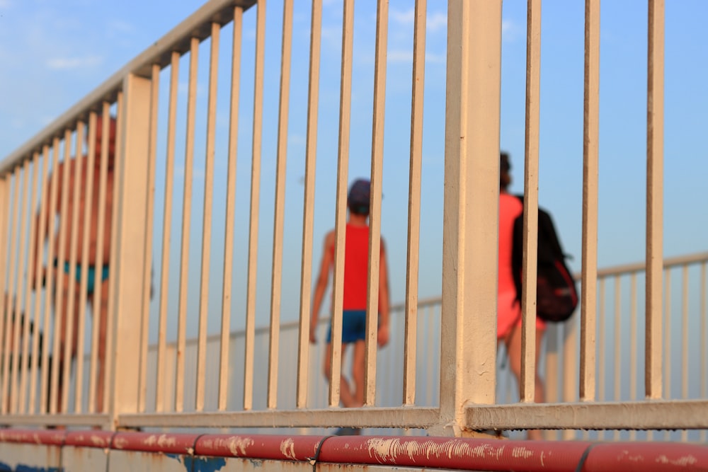 a couple of people walking across a bridge