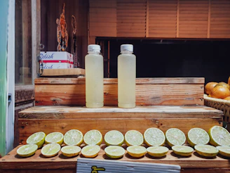 Close-up of vibrant juice bottles lined up on a wooden table, showcasing fresh ingredients.