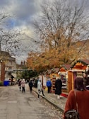 Family exploring a lively market filled with autumnal fruits and local crafts