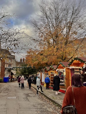 Family exploring a lively market filled with autumnal fruits and local crafts