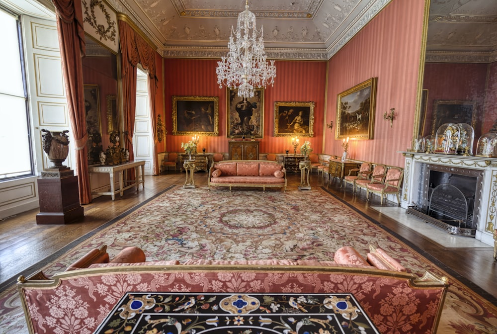 a living room with a chandelier, couches and a fireplace