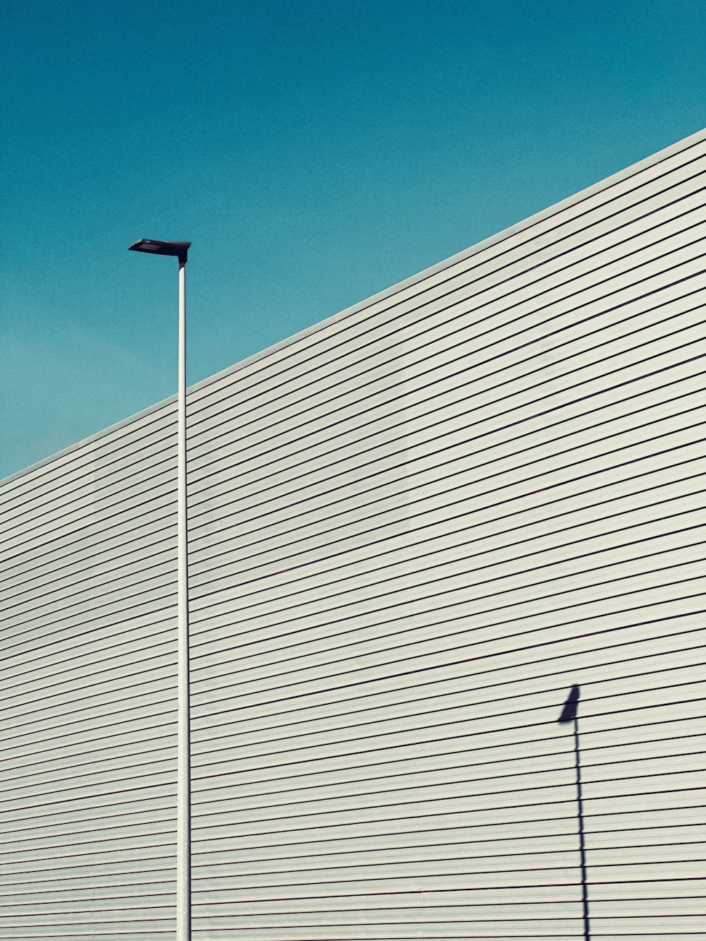 a tall white building with a street light next to it