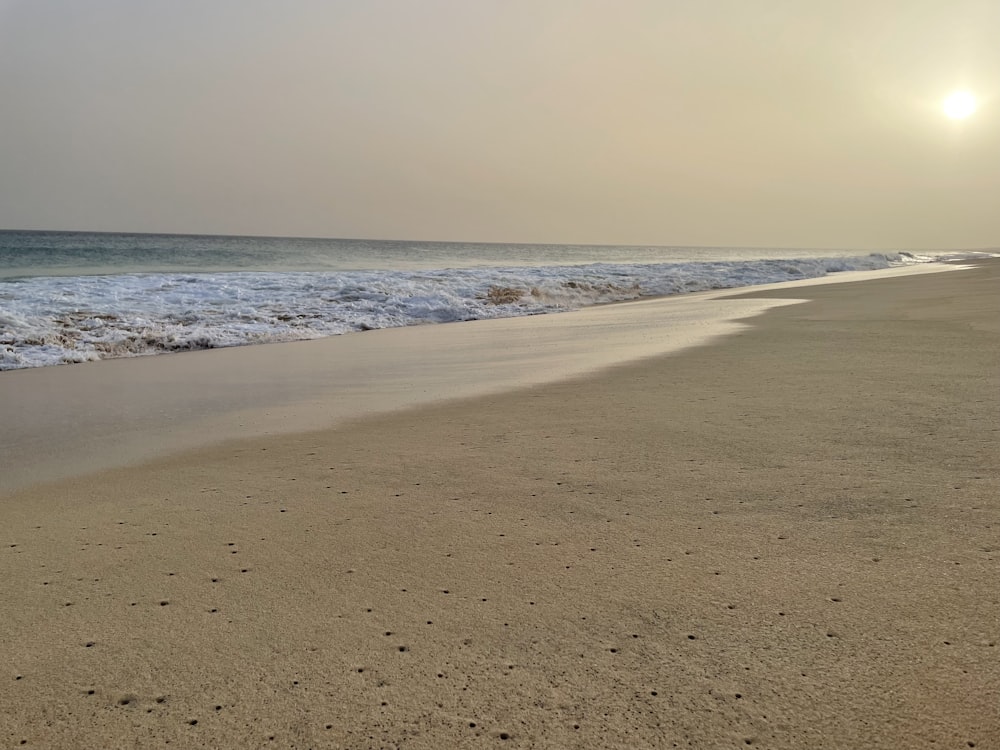 une plage de sable avec des vagues qui arrivent sur le rivage