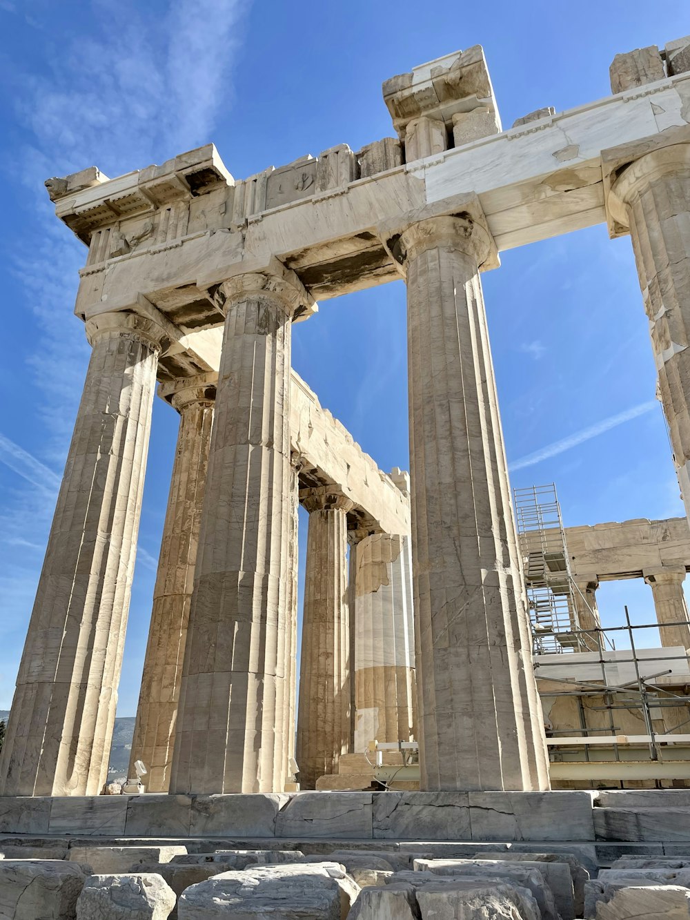 a large stone structure with two columns and a sky background