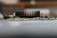 A close-up side view of an electronic circuit board featuring a prominent black heat sink with vertical fins. The board contains small electronic components, including resistors and capacitors, with a blurred background.