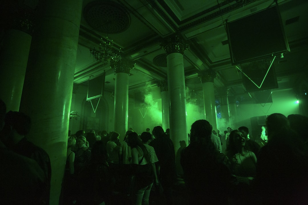 a group of people standing around in a dark room,