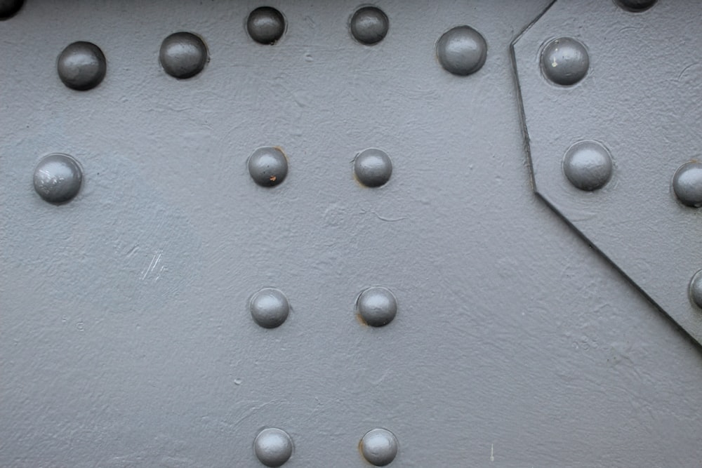 a close up of a metal surface with rivets