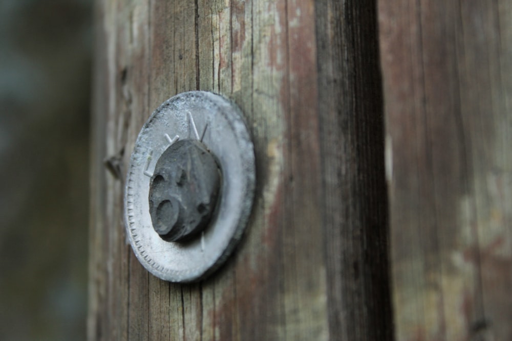 a close up of a metal object on a wooden pole