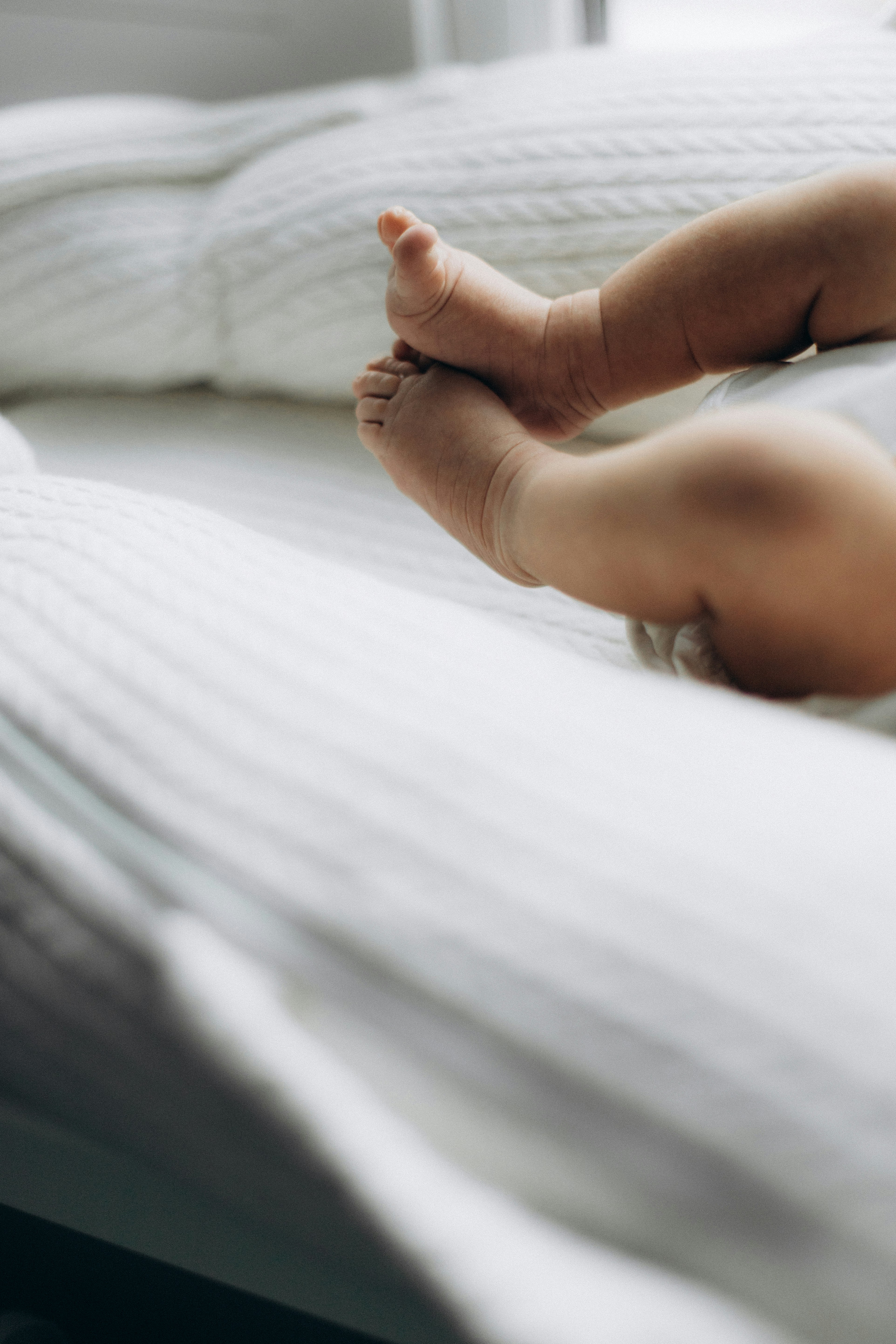 a close up of a baby's foot on a bed