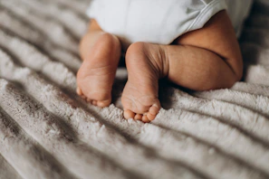 Close-up of a tiny baby’s feet resting on a knitted blue blanket