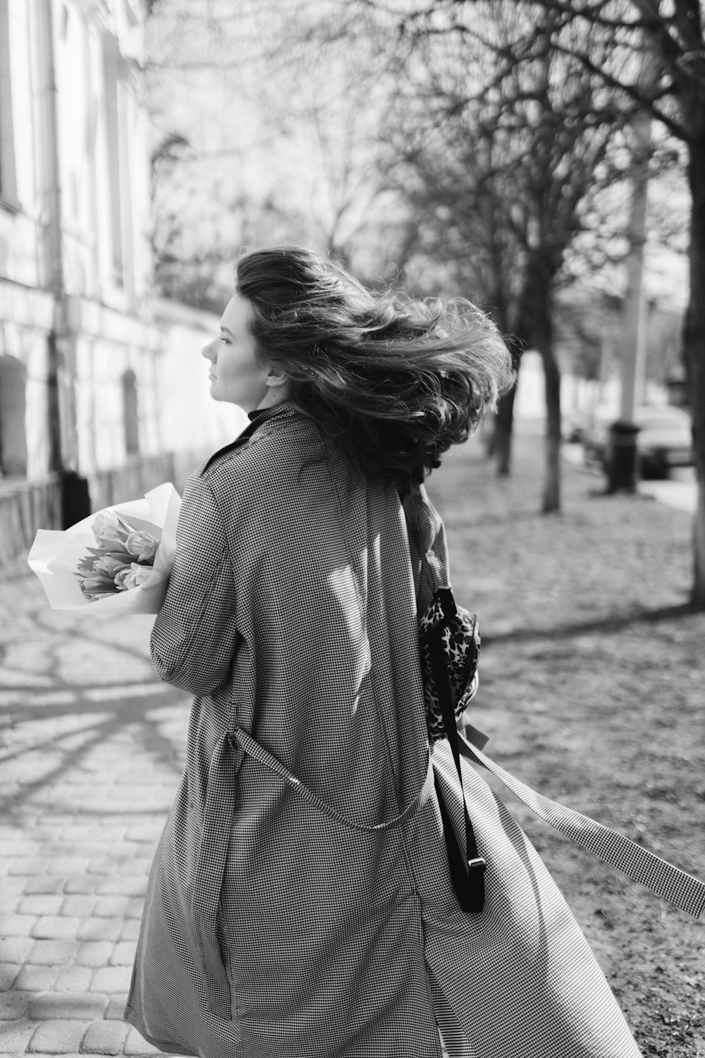 a woman walking down a street holding a bag