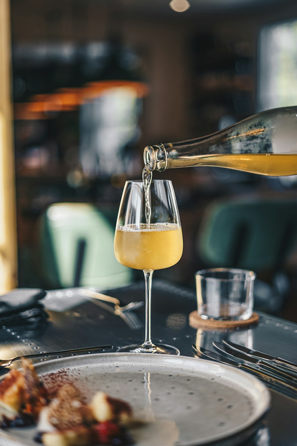 a glass of wine being poured into a wine glass