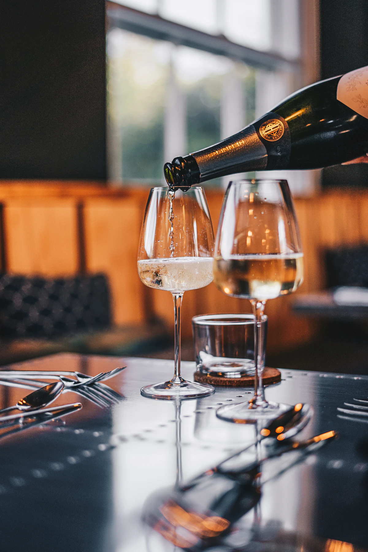 Wine being poured into a glass at the table