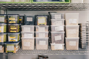 Labeled food inventory containers stored on commercial kitchen shelving
