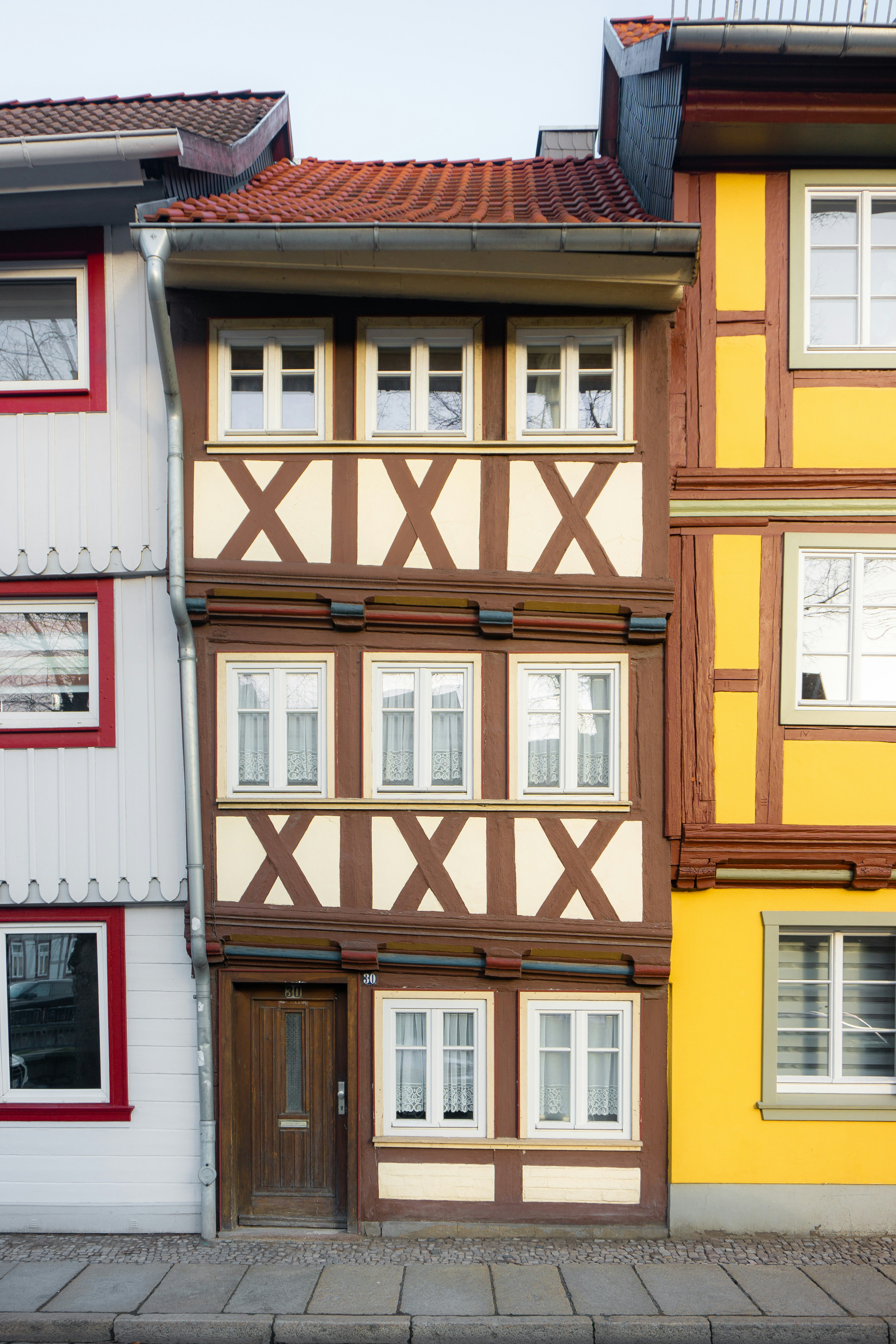una hilera de edificios multicolores con un reloj en cada uno de ellos