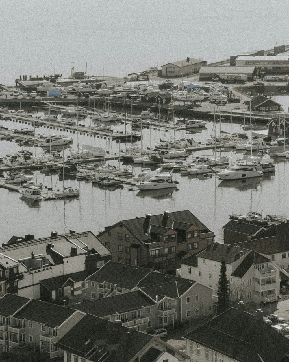 a black and white photo of a harbor filled with boats
