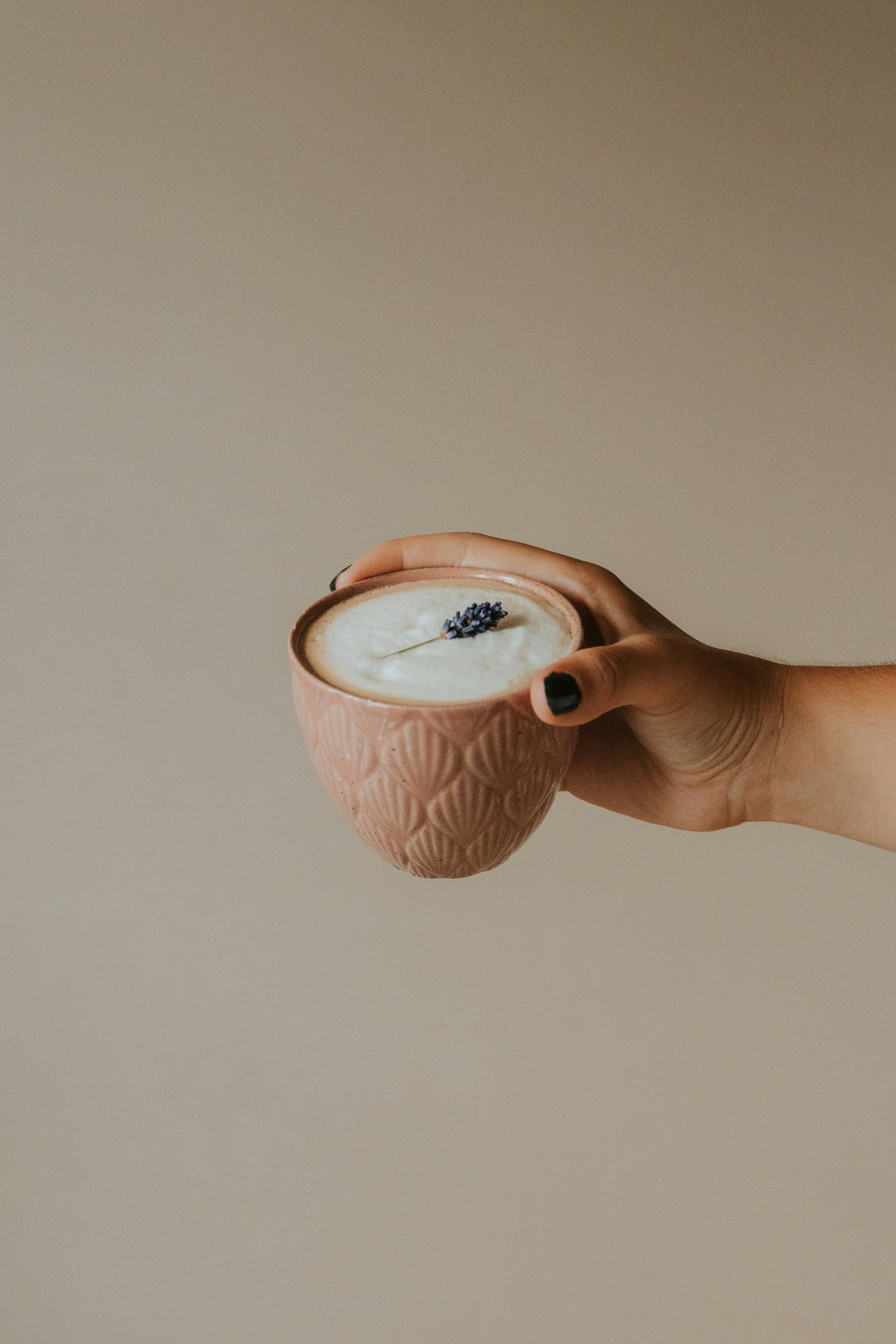 a person holding a cup with a liquid inside of it
