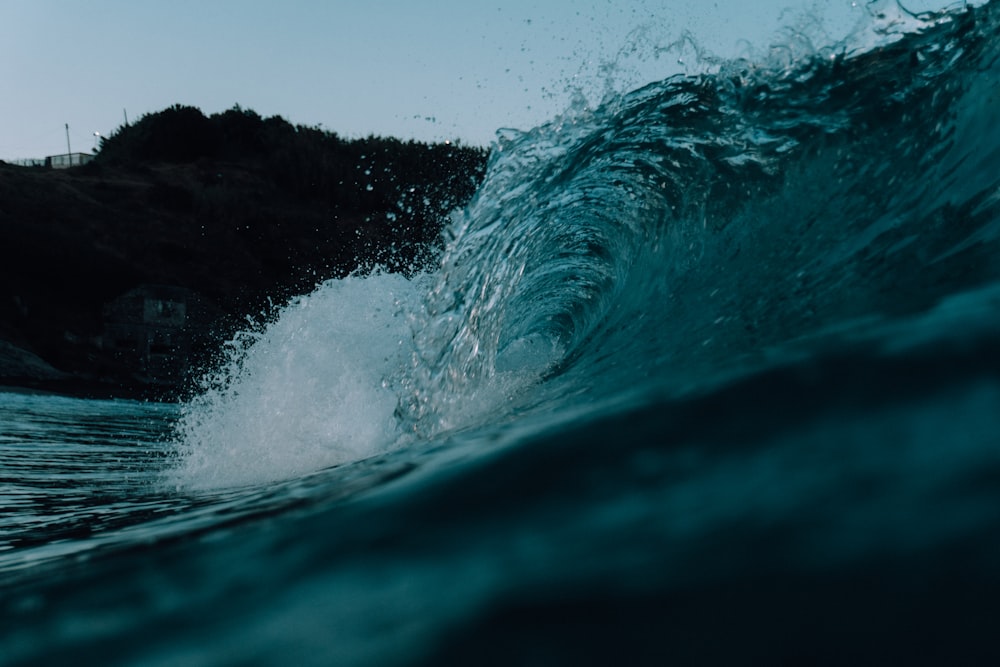 a large wave crashing into the shore of a beach